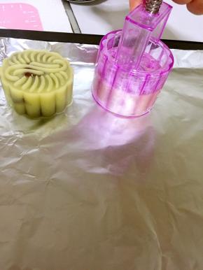 按压模具使月饼胚成型，然后往上提起模具，这样一个月饼就做好了。