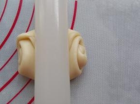 用擀面杖从中间压一下