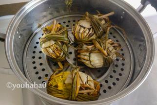 蒸熟的大闸蟹摆盘，有蟹黄的油流在篦子上