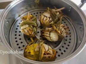 蒸熟的大闸蟹摆盘，有蟹黄的油流在篦子上