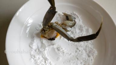 把切开的大闸蟹切面粘上淀粉，避免下锅炒的时候蟹肉流出