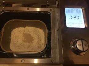 再次将粉类放在液体上面，中间放入酵母，启动和面程序，揉成光滑能拉出有弹性的薄膜后放入黄油，总时间为20分钟