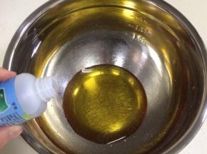 在盆内倒入转化糖浆和枧水，用手动打蛋器搅拌均匀。