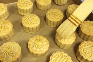 取出月饼，给月饼表面刷上一层薄薄的蛋黄水（1个蛋黄加入8克清水拌匀即可）。