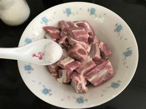 将浸泡好的排骨加入1小勺盐拌匀。