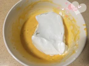 8、挖一大勺蛋白到蛋黄糊里翻拌均匀，再取1/3蛋白倒入蛋白里翻拌均匀；