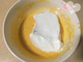 8、挖一大勺蛋白到蛋黄糊里翻拌均匀，再取1/3蛋白倒入蛋白里翻拌均匀；