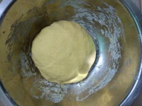 南瓜汁倒入面粉里揉成光滑面团。