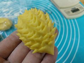 用小剪刀剪出一根根小刺。放在油纸上，在眼睛的位置沾点水粘上芝麻。