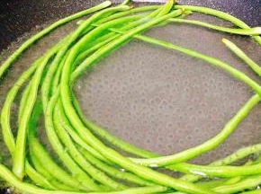 锅里放水煮开，豆角下锅煮