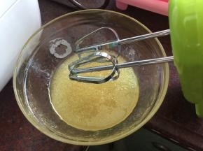 植物油分次加入转化糖浆中，用打蛋器搅拌均匀