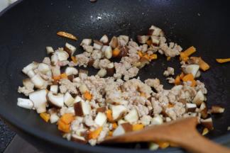 肉馅变色后，把香菇丁也放进去翻炒；