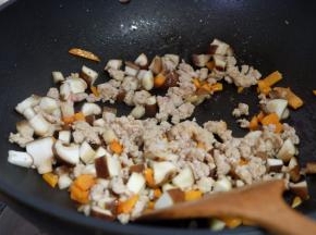 肉馅变色后，把香菇丁也放进去翻炒；