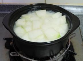 这个时候，砂锅的米饭表面冒大泡了，把切好的冬瓜块放进砂锅；继续小火焖煮；