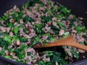 把猪肉馅放进去翻炒至肉馅变色，关火。把切碎的小白菜放进去拌均匀；