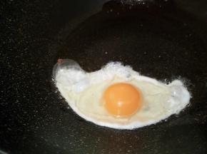 锅里放油少许，打入一个鸡蛋，中火慢慢煎
