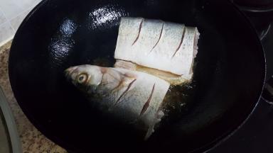 12.油热后，快速放入鱼段并盖上锅盖，防止油飞溅。