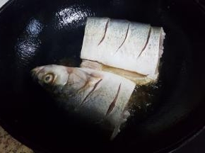 12.油热后，快速放入鱼段并盖上锅盖，防止油飞溅。