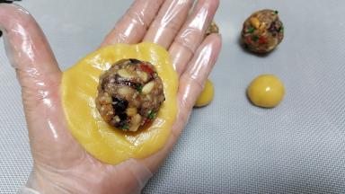 6．将一份馅料放在饼皮上，包裹馅料时，尽量避免饼皮与馅料中间有空气。