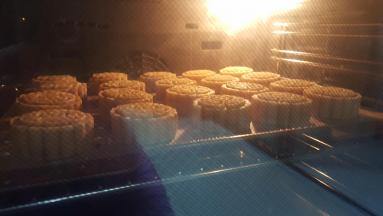 11．在月饼生胚上，喷少量的水，放入已经预热好的烤箱中上下火180度，烤7分钟取出后，表面刷薄薄的一层蛋黄水，继续放入烤箱中，上下火180度，烤13分钟。