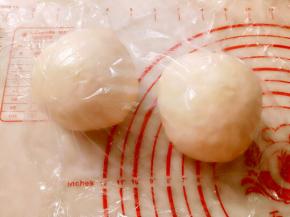 取出面团排气后，平均分成2份，滚圆盖保鲜膜松弛20分钟。