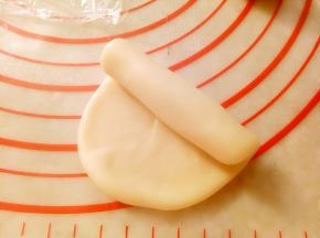 把包好的酥皮依次用擀面杖擀成牛舌形（长度10CM左右）卷起来,盖保鲜膜松弛10分钟。