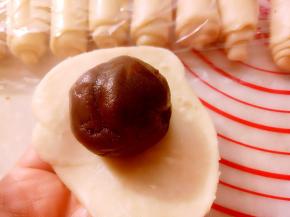 用擀面杖擀成圆形放入之前准备好的豆沙蛋黄馅包好。