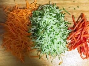 5.蒸饭的过程中制作拌料汤汁等，先将黄瓜，胡萝卜，红辣椒切丝