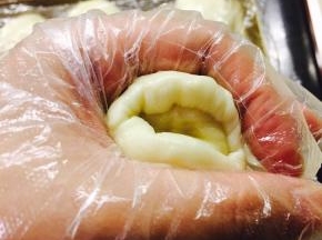 虎口收紧，推皮收口。收口朝下。放置于烤盘中，盖保鲜膜放置15分钟。