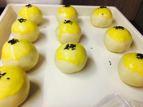 包好的蛋黄酥，放置于烤盘中。蛋黄液刷2次。第一次干后刷第二次。手指沾蛋黄液，沾黑芝麻，点到蛋黄酥上。烤箱180度，烤制30分钟，如果你的烤箱上色比较快，建议覆盖锡纸。