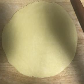 10.醒好的面按扁，擀薄片，底部放少许面粉防粘