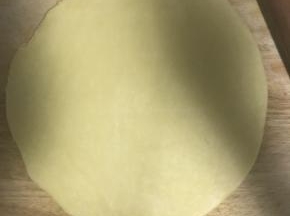 10.醒好的面按扁，擀薄片，底部放少许面粉防粘