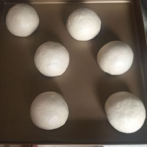 收口捏紧，朝下放入烤盘。然后继续发酵至两倍大。（我放烤箱发酵的）