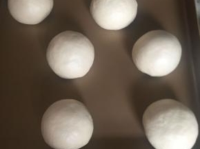 收口捏紧，朝下放入烤盘。然后继续发酵至两倍大。（我放烤箱发酵的）