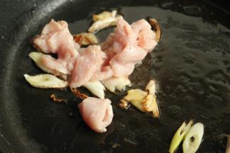 炒锅放油，放入葱姜爆香，下入肉片炒散。