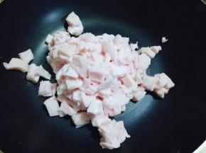 将切好小块的猪板油放入锅中。
