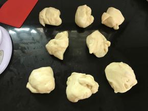 将发酵好的面团按压排气，分割成8等份。