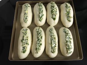 放入温暖处二次发酵至两倍大，用刀在表面划一道切口，在划刀处放上香葱馅。