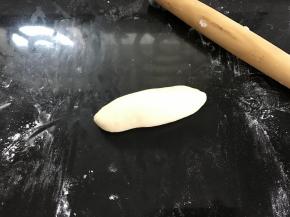 从上往下卷起整成橄榄形。