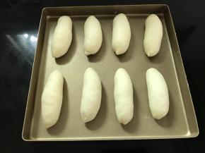 依次做好所有的面包胚，码在烤盘里。