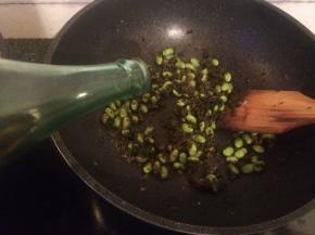 锅中热油，加入咸菜毛豆，加入料酒翻炒