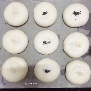 发酵好的面团表面喷水，撒上黑芝麻或白芝麻