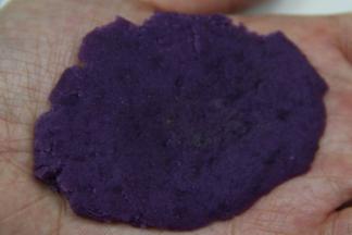 把一个小紫团放在掌心，双手用力压平