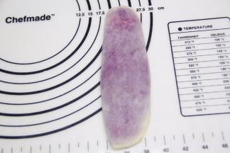 油酥面团直立放着，然后用擀面杖擀成长条椭圆。