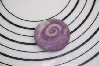 切面朝上把面团压扁，擀成圆形，尽量中间厚四周薄。