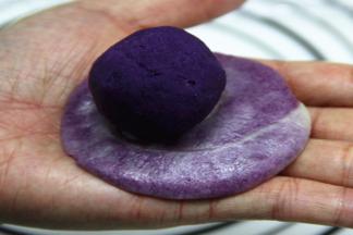 再放入一个紫薯馅，慢慢往上收口包好，不能搓，会使花纹变形。