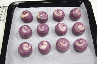 将做好的紫薯蛋黄酥摆入烤盘上。