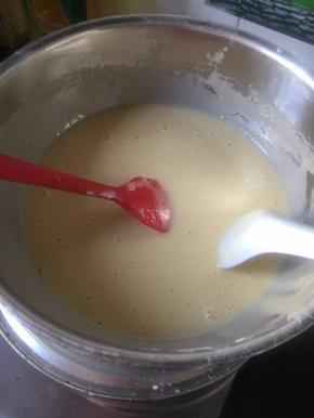 用刮刀将边上的面粉和面糊刮下