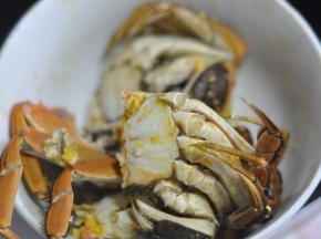 将背上的壳完整掰下来，取出去掉蟹肠、蟹心、蟹腮、蟹胃，将大闸蟹掰成两半。