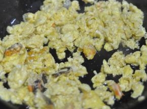 用筷子将蛋液搅拌，形成细碎的鸡蛋。